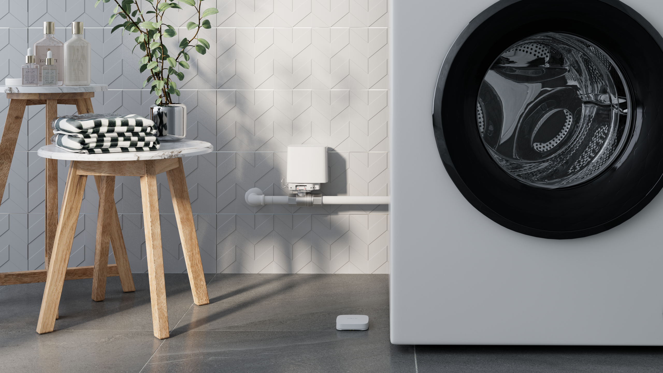 Electrovalva Wireless AJAX WaterStop 1” (25 DN) instalată lângă mașina de spălat pentru control eficient al apei.