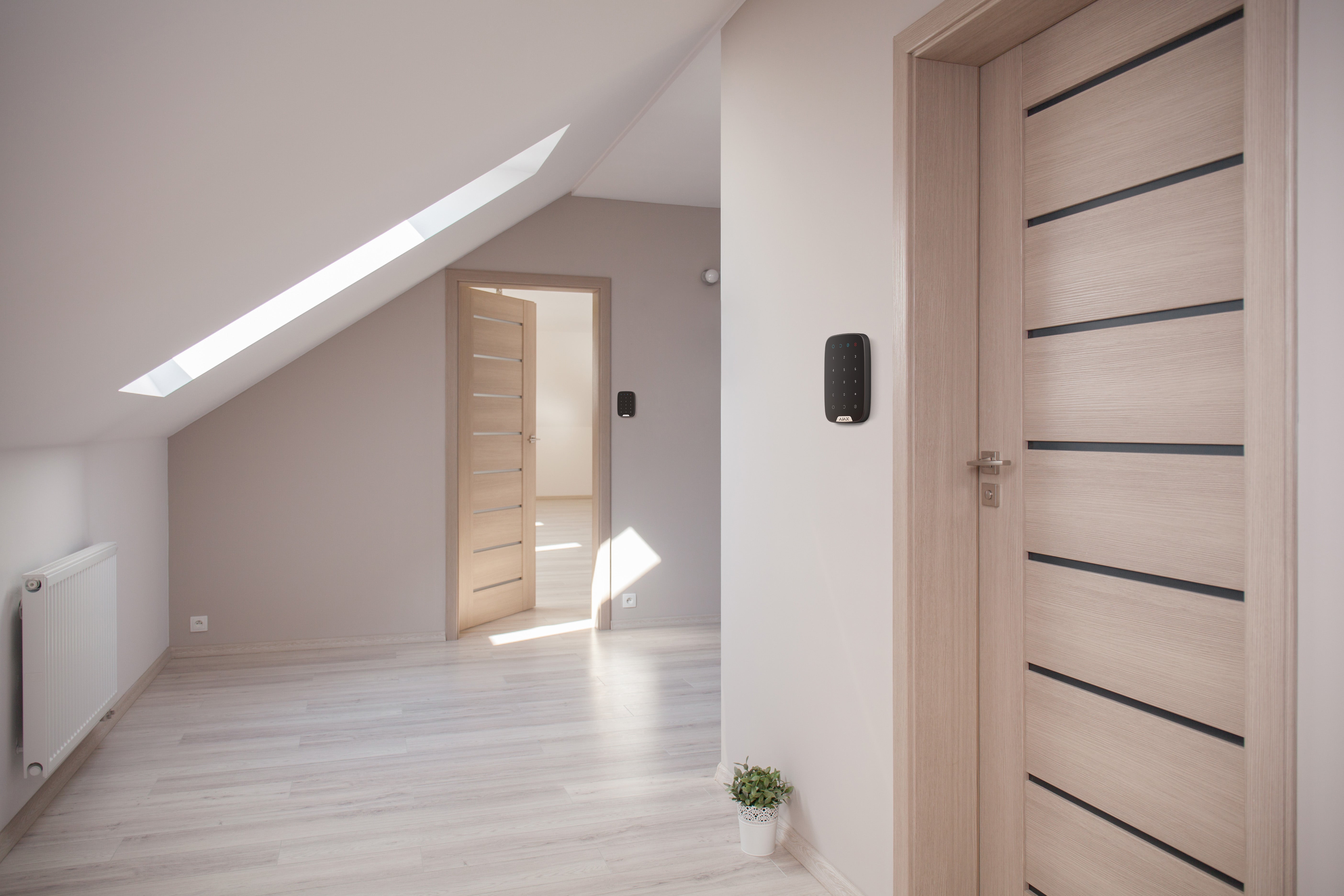 Tastatura wireless, AJAX KeyPad montată pe perete într-un interior modern, perfectă pentru controlul accesului.