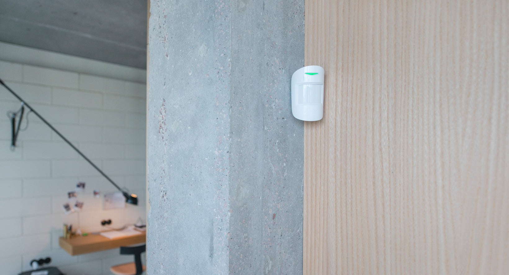 Detector PIR wireless, AJAX MotionProtect Plus montat pe ușă, ideal pentru securitatea locuinței tale.
